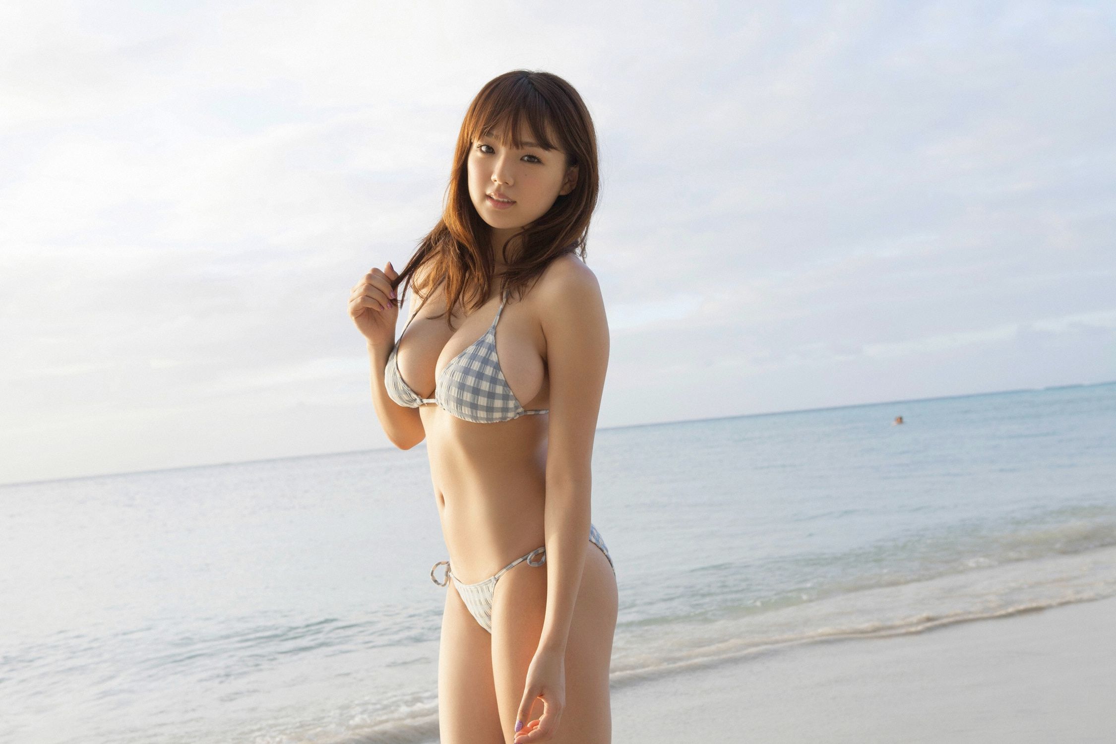 Молодая японка в цельном купальнике показывает себя спереди и сзади